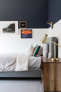 a bed room with a neatly made bed and some pictures on the wall above it