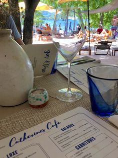 the table is set with wine glasses and menus for an outdoor dining area on the beach