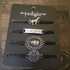 the twilight saga bracelets are on display in front of a black card board with an image of a dog