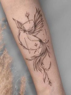 a tattoo on the arm of a woman with a bird and arrow in its beak