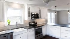 a kitchen with white cabinets and black counter tops