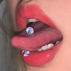 a woman's tongue with white teeth and blue flowers on the end of it