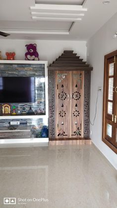 a living room with a flat screen tv mounted on the wall and decorative wooden doors