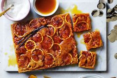 slices of cake on a cutting board with sauces and spoons