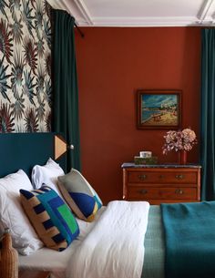 a bedroom with red walls and green curtains