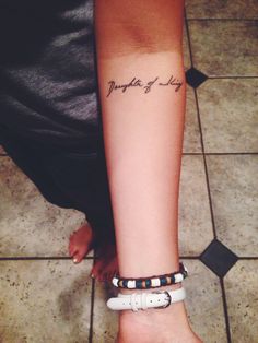 a woman's arm with a tattoo that reads daughter of the king on it