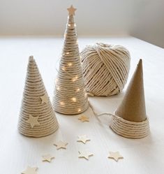 twine wrapped christmas trees with star lights on the top and white stars around them