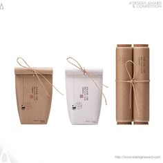 three packages tied up with twine on top of each other in front of a white background