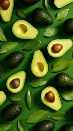 avocados and leaves on a green surface