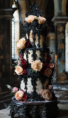 a three tiered cake with flowers on it's side and black icing