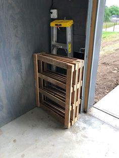 a stack of wooden crates sitting in front of a wall with a ladder on it