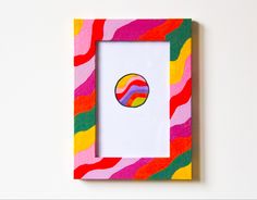 a multicolored photo frame with a round sticker on it