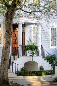 a white house with stairs leading to the front door