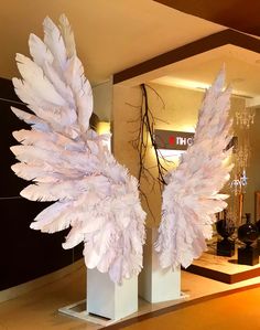 two tall white sculptures with large feathers on them