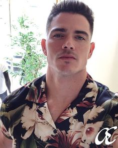 a man in a flowered shirt looking at the camera