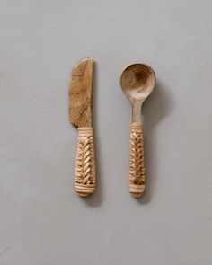 two wooden utensils with braided handles on a gray surface next to each other