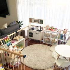 a living room filled with furniture and a white rug on top of a hard wood floor