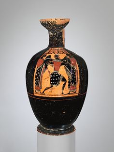 an ancient vase is displayed on a pedestal