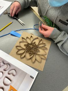 a person working on some art work with scissors