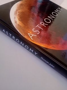 the book astronomy sits on a white surface