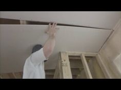 a man is working on the ceiling in his house