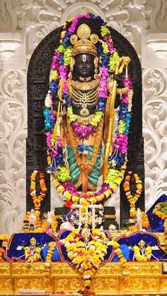 the statue is decorated with flowers and garlands