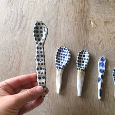 four toothbrushes are lined up on a table, one is painted blue and the other is white