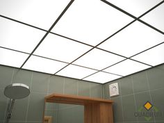 a bathroom with green tiled walls and a wooden table in the corner under a white skylight