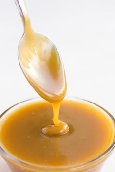 a spoon full of caramel sauce being drizzled on top of it