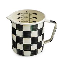 a black and white checkered pitcher with a measuring tape on it's side