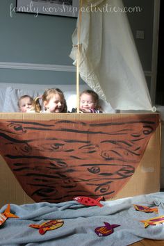 three children in a boat made out of cardboard