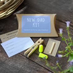 a new dad kit is sitting on a wooden table next to some crafting supplies