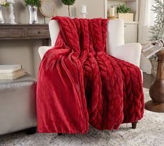 a red blanket sitting on top of a white chair