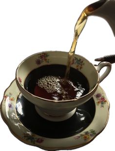 tea being poured into a cup with saucer