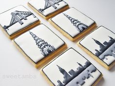 four decorated cookies with the eiffel tower in black and white icing on them