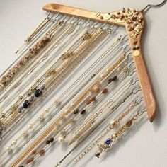 a wooden hanger filled with lots of different types of jewelry