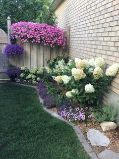 the flowers are blooming all over the side of the house and around the fence