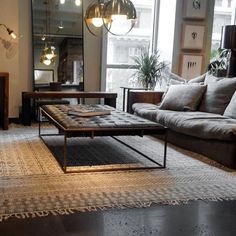 a living room with couches, tables and lamps on the windowsills in front of a large window