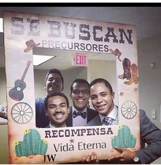 a man holding up a sign with three men in it