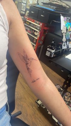 a woman's arm with a tattoo on it and a bird in the middle