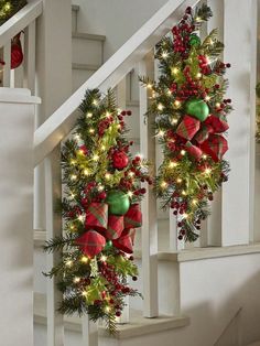 two christmas wreaths hanging from the banister