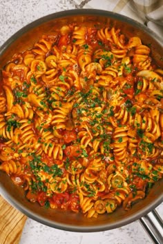 a pan filled with pasta and sauce on top of a table