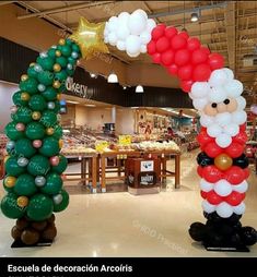 two inflatable christmas trees with santa clause on top and balloons attached to them