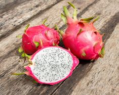 two dragon fruit cut in half on a wooden table