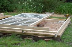 a wooden structure with glass panes in the middle and some wood pallets around it