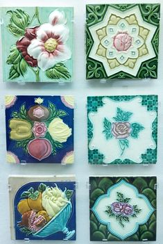 four different colored glass tiles with flowers on them