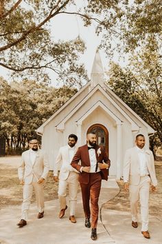 a group of men in suits walking towards a church