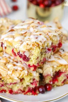 cranberry and almond bars stacked on top of each other with white icing