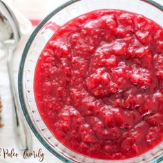 a glass bowl filled with cranberry sauce on top of a table