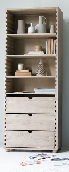 an open bookcase with drawers and vases on the top shelf in front of it